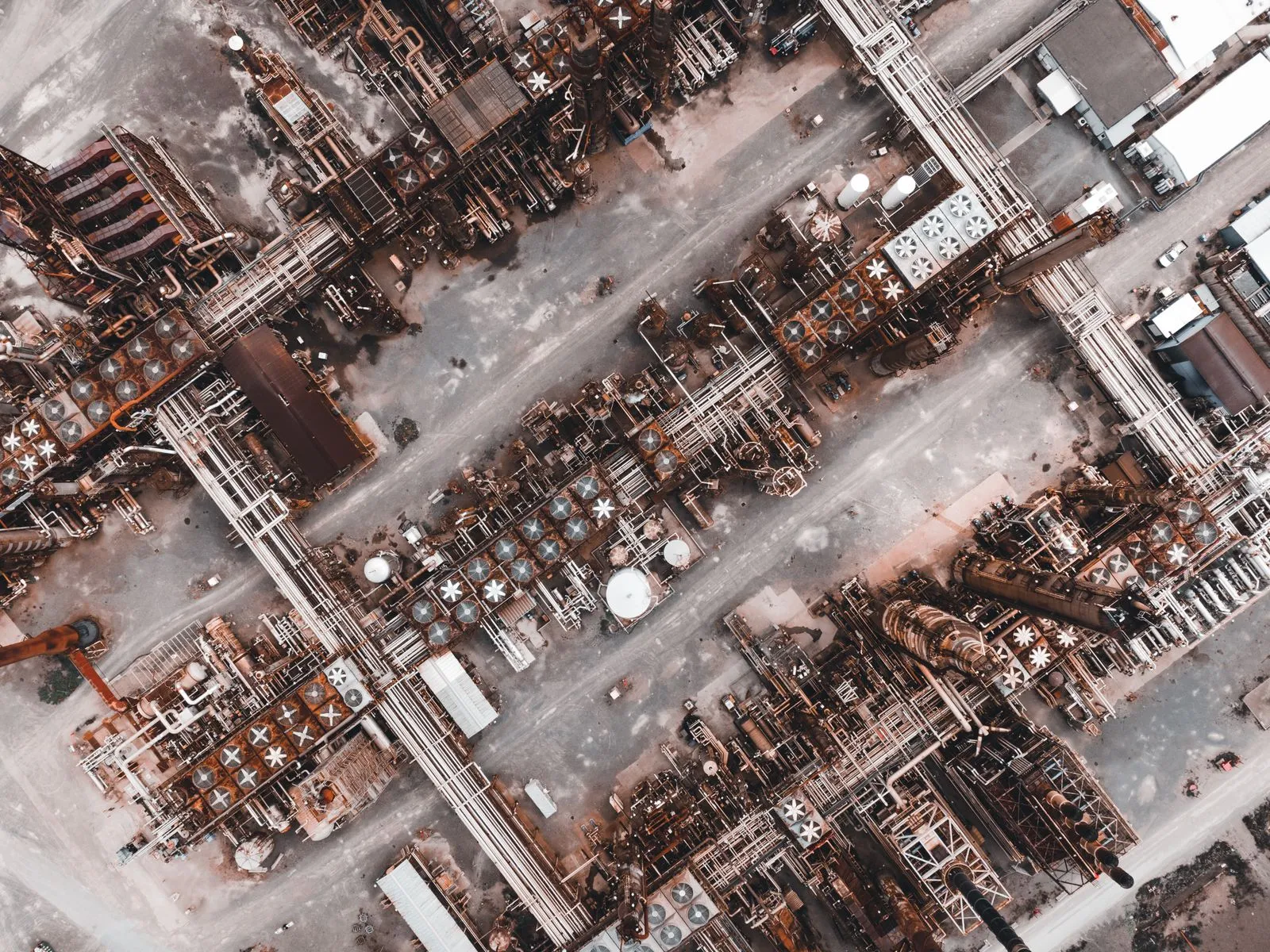 Drone shot capturing the intricate layout of a large industrial factory from above.